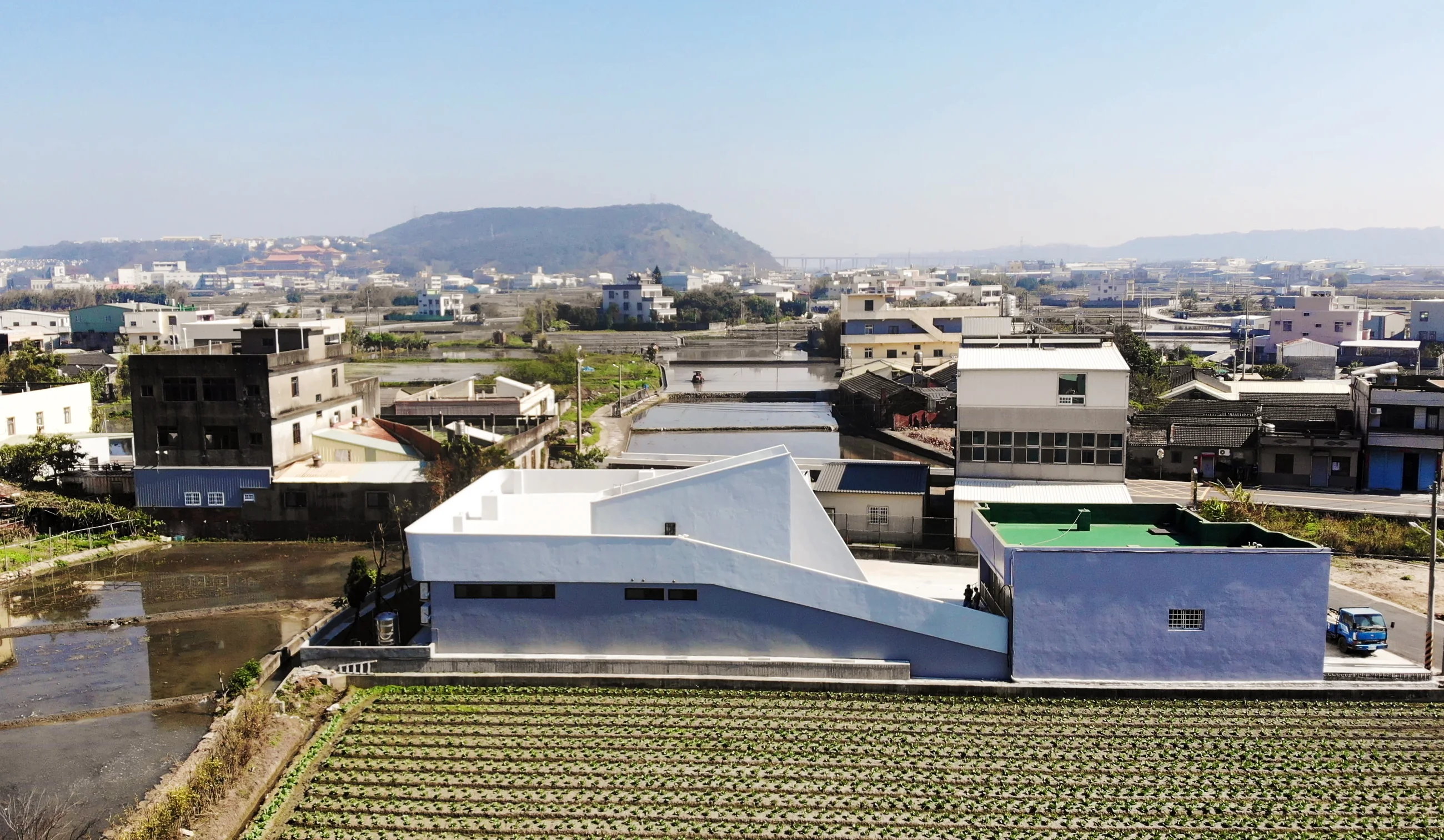 武陵市民活動中心、田野、鄰里聚落與鐵砧山的空拍關係